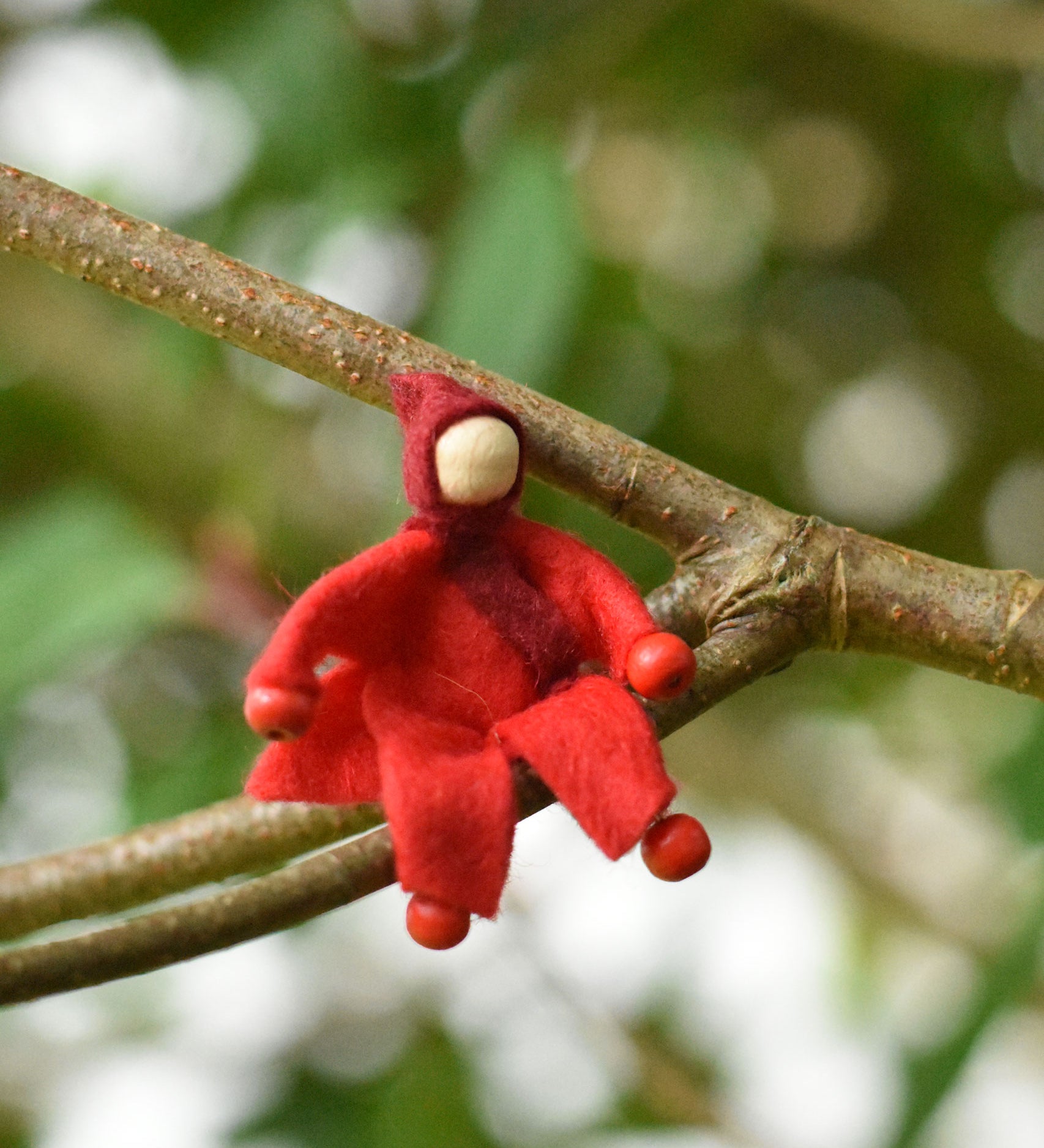 A red felt Kraul Little Passenger Doll. These pose-able dolls are perfect to fit inside smaller toy vehicles and for use with the Kraul cable cars.