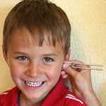 A tuning fork from the Kraul listening kit held next to a child's ear