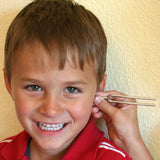 A tuning fork from the Kraul listening kit held next to a child's ear