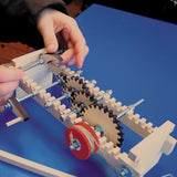 A child using the Kraul Gearwheels wooden cog wheels Experiment Kit whis has been assembled. Discover a world of wonder with Kraul STEM science kits and educational toys available at Babipur.