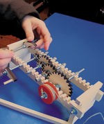 A child using the Kraul Gearwheels wooden cog wheels Experiment Kit whis has been assembled. Discover a world of wonder with Kraul STEM science kits and educational toys available at Babipur.