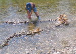 Child playing with Kraul Wooden River Wheel in river