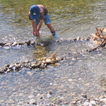 Child playing with Kraul Wooden River Wheel in river