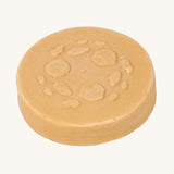 Close-up of the Lamazuna Keratin Repair Solid Shampoo Bar, a round vegan shampoo bar enriched with plant-based keratin.