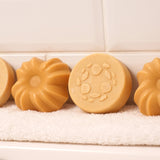 Lamazuna Keratin Repair solid shampoo bar and Keratin Shine solid conditioner bar displayed side by side on a white towel, showing the round shampoo bar and fluted conditioner bar