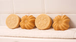 Lamazuna Keratin Repair solid shampoo bar and Keratin Shine solid conditioner bar displayed side by side on a white towel, showing the round shampoo bar and fluted conditioner bar