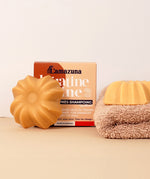 Lamazuna Keratin Shine conditioner bar positioned in front of its box packaging on a soft neutral background