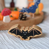 A Lanka Kade wooden toy bat placed in front of an Autumnal themed Grimm's celebration themed set up. 