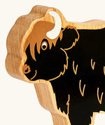 Close up of the painted facial features on the Lanka Kade black highland cow wooden toy figure. 