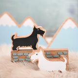 Lanka Kade scottie dog figure standing on a wooden wall piece and a white scottie dog figure