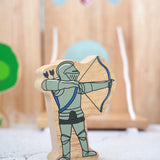 Lanka Kade wooden blue armoured knight archer figure with a wooden castle in the background.