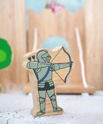 Lanka Kade wooden blue armoured knight archer figure with a wooden castle in the background.