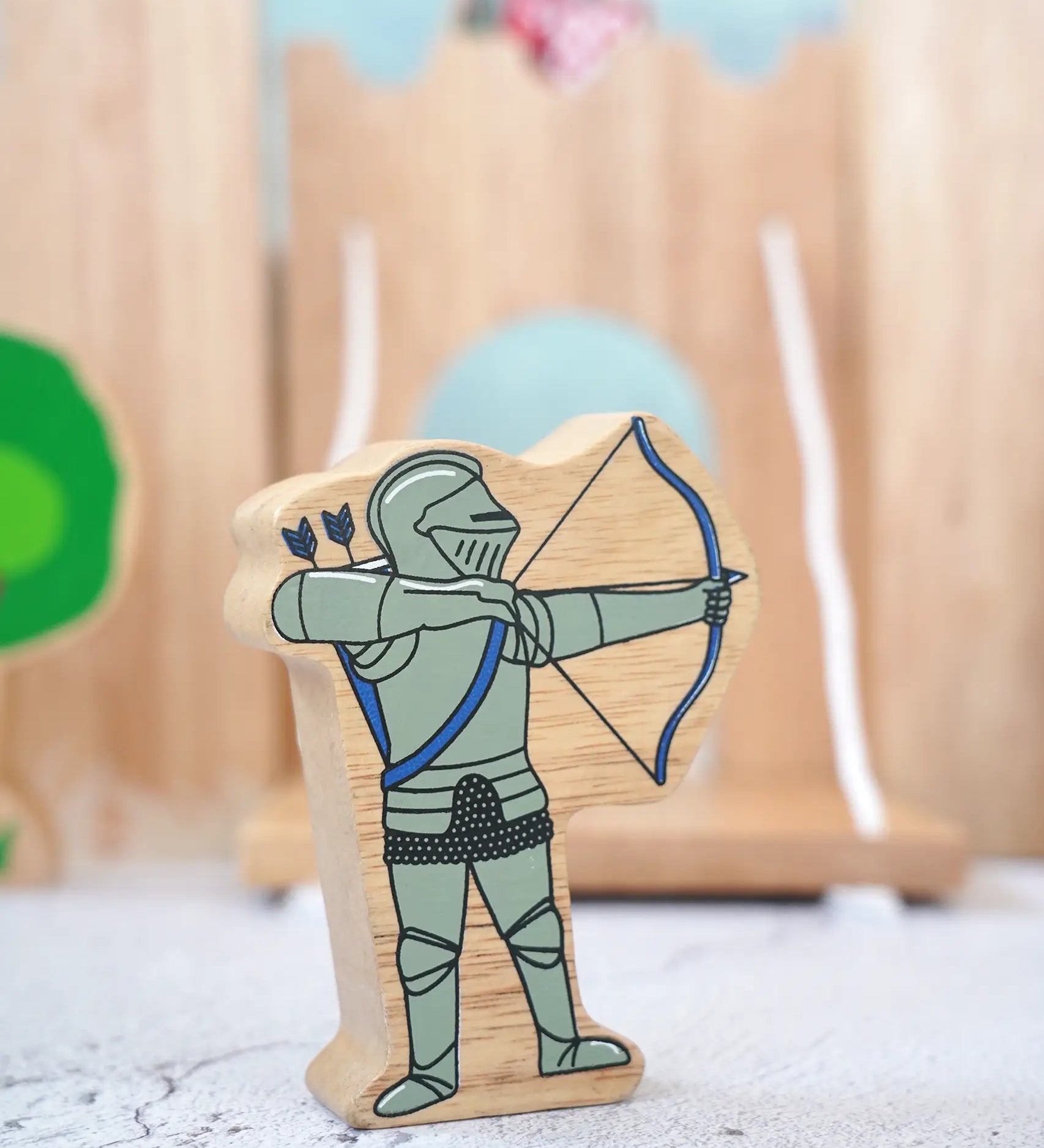 Lanka Kade wooden blue armoured knight archer figure with a wooden castle in the background.