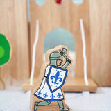 Lanka Kade wooden blue knight figure with a battle axe and shield with a wooden castle in the background