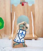 Lanka Kade wooden blue knight figure with a battle axe and shield with a wooden castle in the background