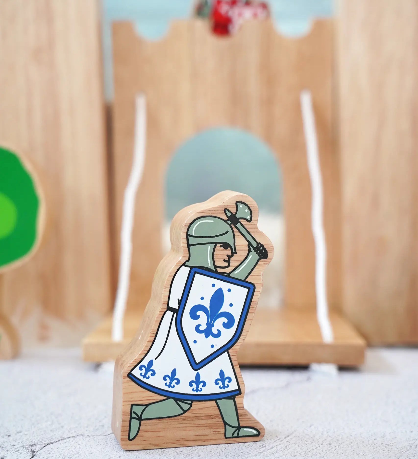 Lanka Kade wooden blue knight figure with a battle axe and shield with a wooden castle in the background