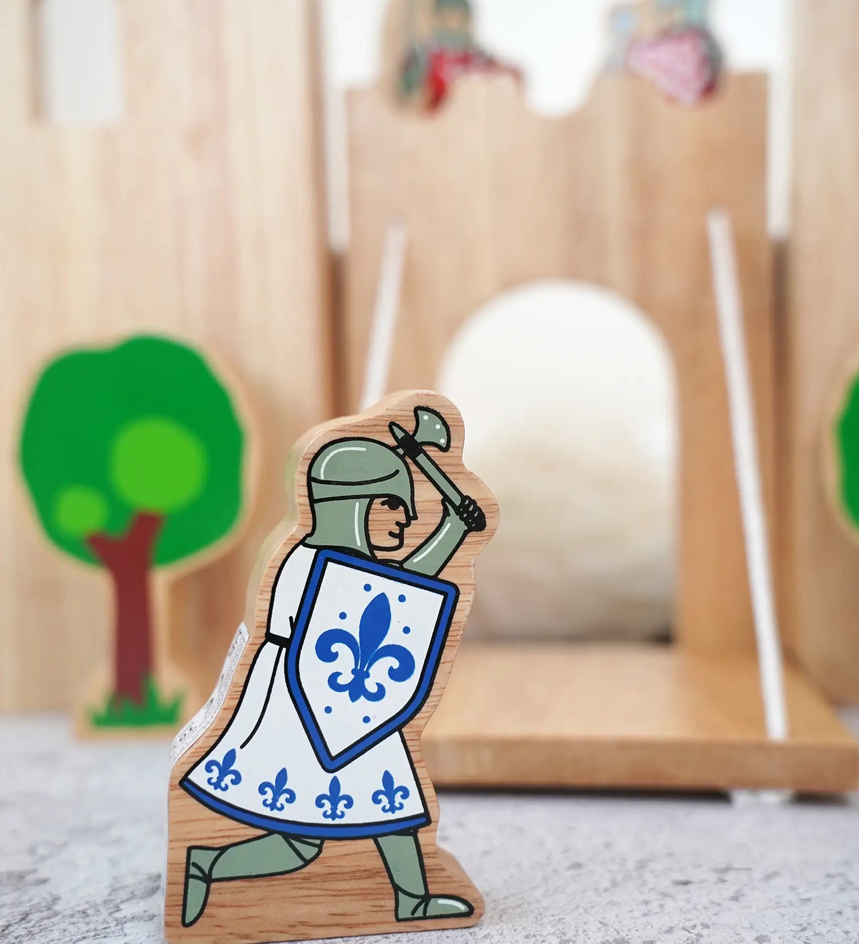Lanka Kade wooden blue knight figure with a battle axe and shield with a wooden castle in the background