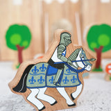 Lanka Kade wooden blue knight on horseback figure with a castle and tree figures in the background