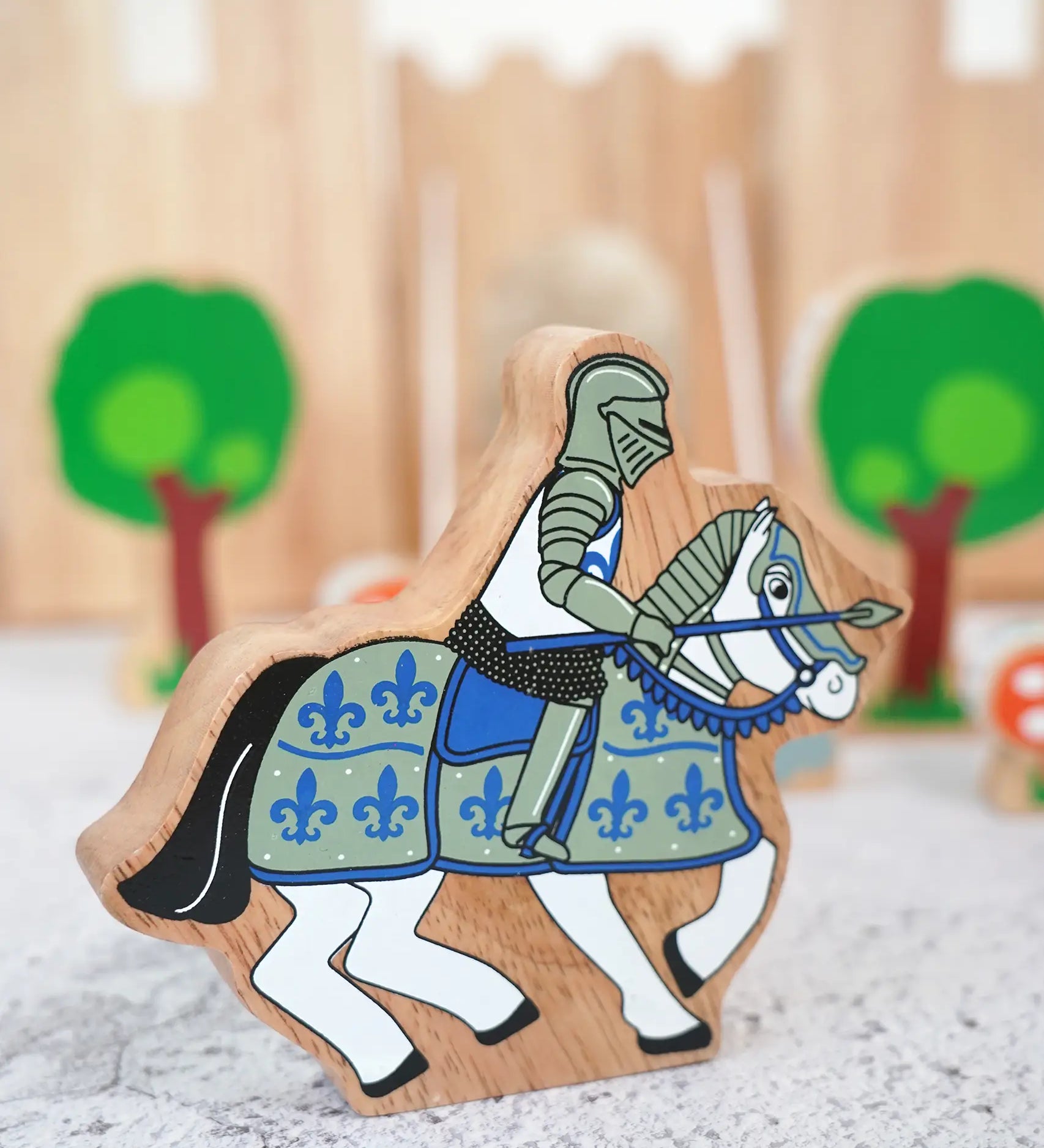 Lanka Kade wooden blue knight on horseback figure with a castle and tree figures in the background