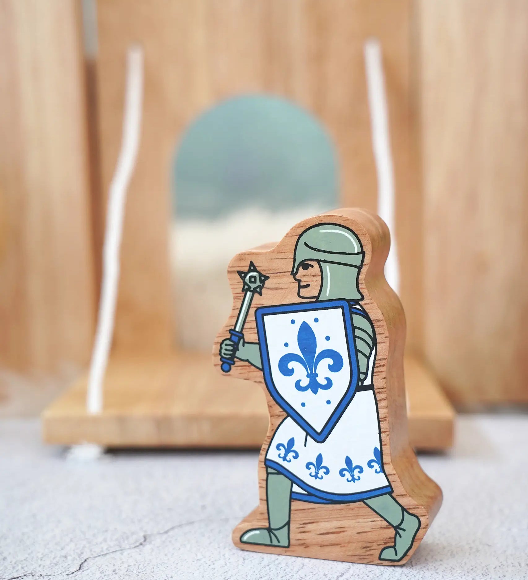 Lanka Kade chunky wooden blue knight figure with morning star weapon standing in front of a wooden castle