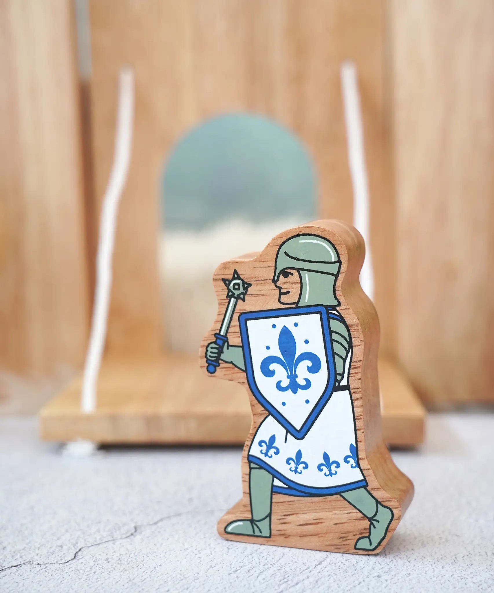 Lanka Kade chunky wooden blue knight figure with morning star weapon standing in front of a wooden castle