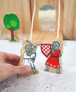 Adult hand holding the Lanka Kade blue knight with raised sword next to a red knight figure showing scale