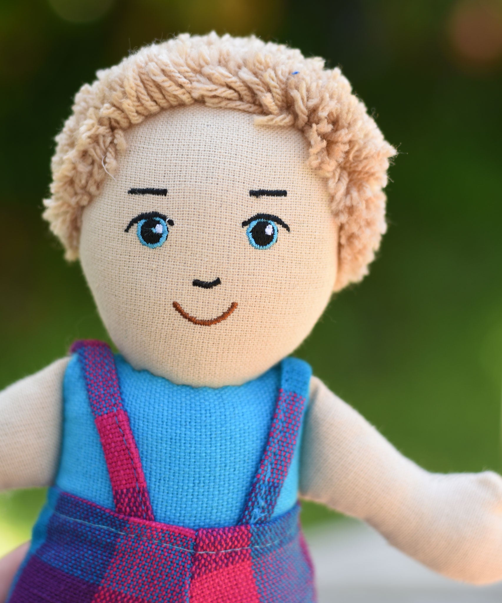 A close up of the face on the Lanka Kade Boy Doll with White Skin and Blonde Hair.