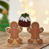 Two Lanka Kade gingerbread men wooden toy figure placed on a wooden surface in the Babipur playroom balancing a Christmas pudding on their arms.