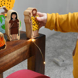 A child holding the cave fan figure from the Lanka Kade Prehistoric Playset. A play set that contains 8 wooden figure and scenery pieces. These wooden toy figures are part of a huge range of Lanka Kade fair trade, wooden toys available here at Babipur.