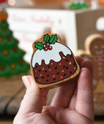 Lanka Kade Christmas pudding wooden toy figure in an adults hand. 
