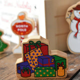 Lanka Kade wrapped presents wooden Christmas wooden toy figure placed on a wooden surface in the Babipur playroom. 