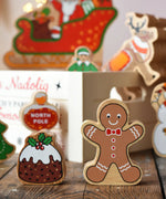 Lanka Kade gingerbread man and Christmas pudding wooden toy figure placed on a wooden surface in the Babipur playroom.