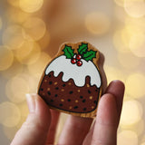 Lanka Kade Christmas pudding wooden toy figure in an adult's hand.