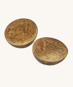 A close up of the coconut bowls from the coconut water play set showing the 2 shells with holes in the bottom for water to pour through them