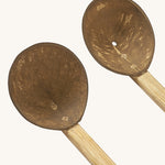 A close up of the 2 Lanka Kade coconut utensils set showing the ladle and colander on wooden handles.
