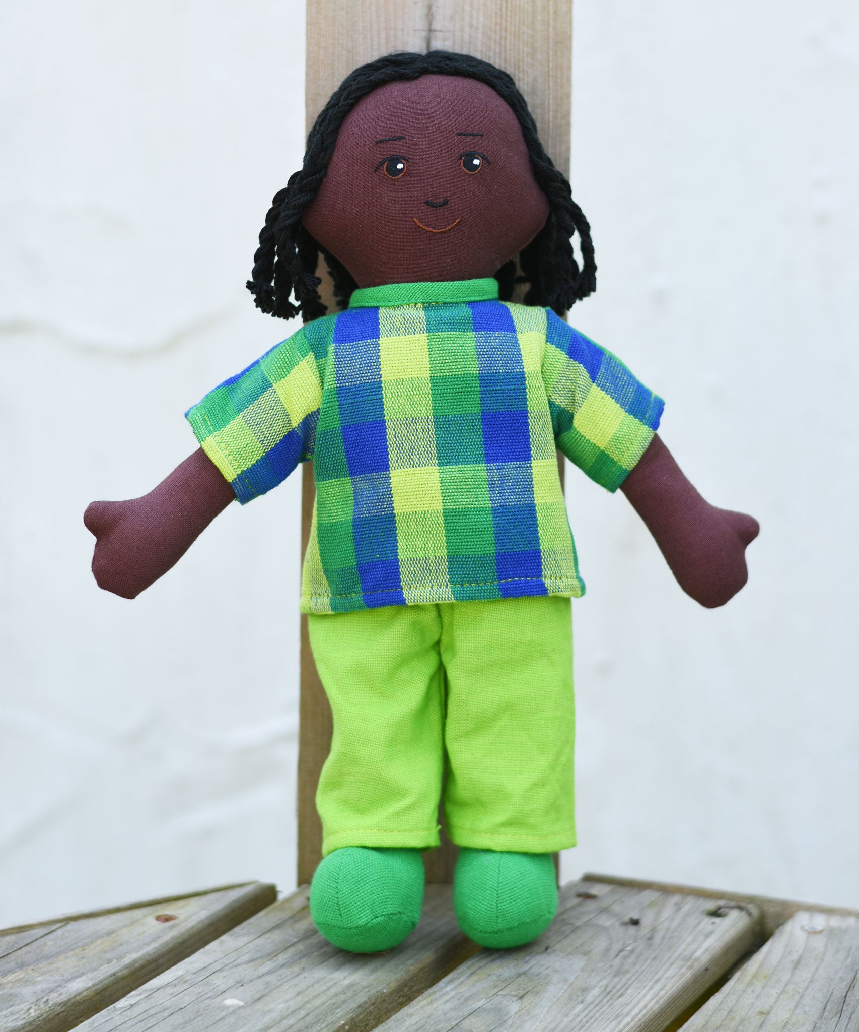 A Lanka Kade Rag Doll Dad - Black Skin, Black Hair placed on wooden decking outdoors.