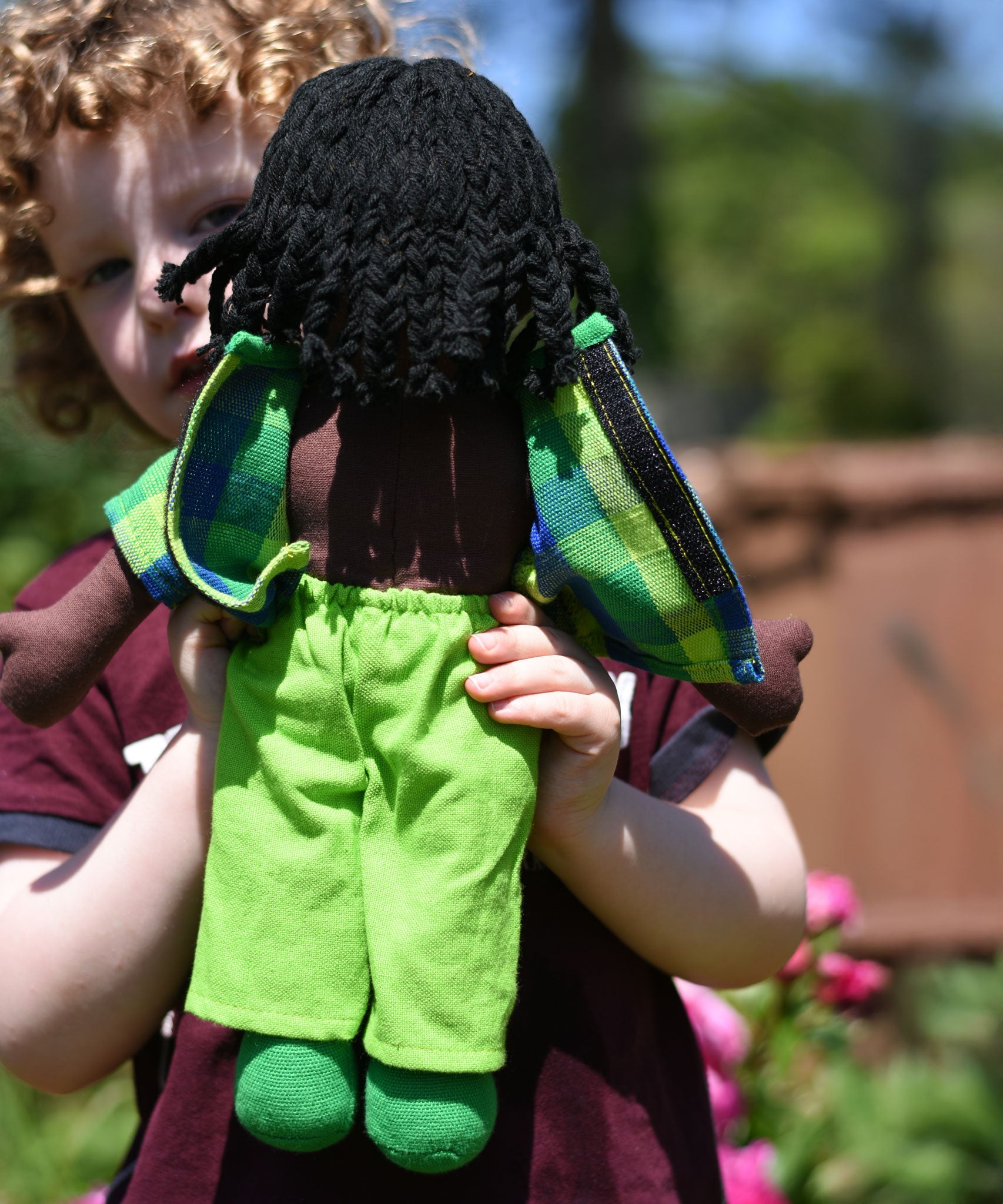 A close up of the back of the Lanka Kade Rag Doll Dad with Black Skin, Black Hair. The back of teh t-shirt s shown open.