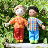 Two Lanka Kade Fair Traded dad dolls placed on a slate surface outdoors. One has white skin and blonde hair the other has brown skin and black hair.