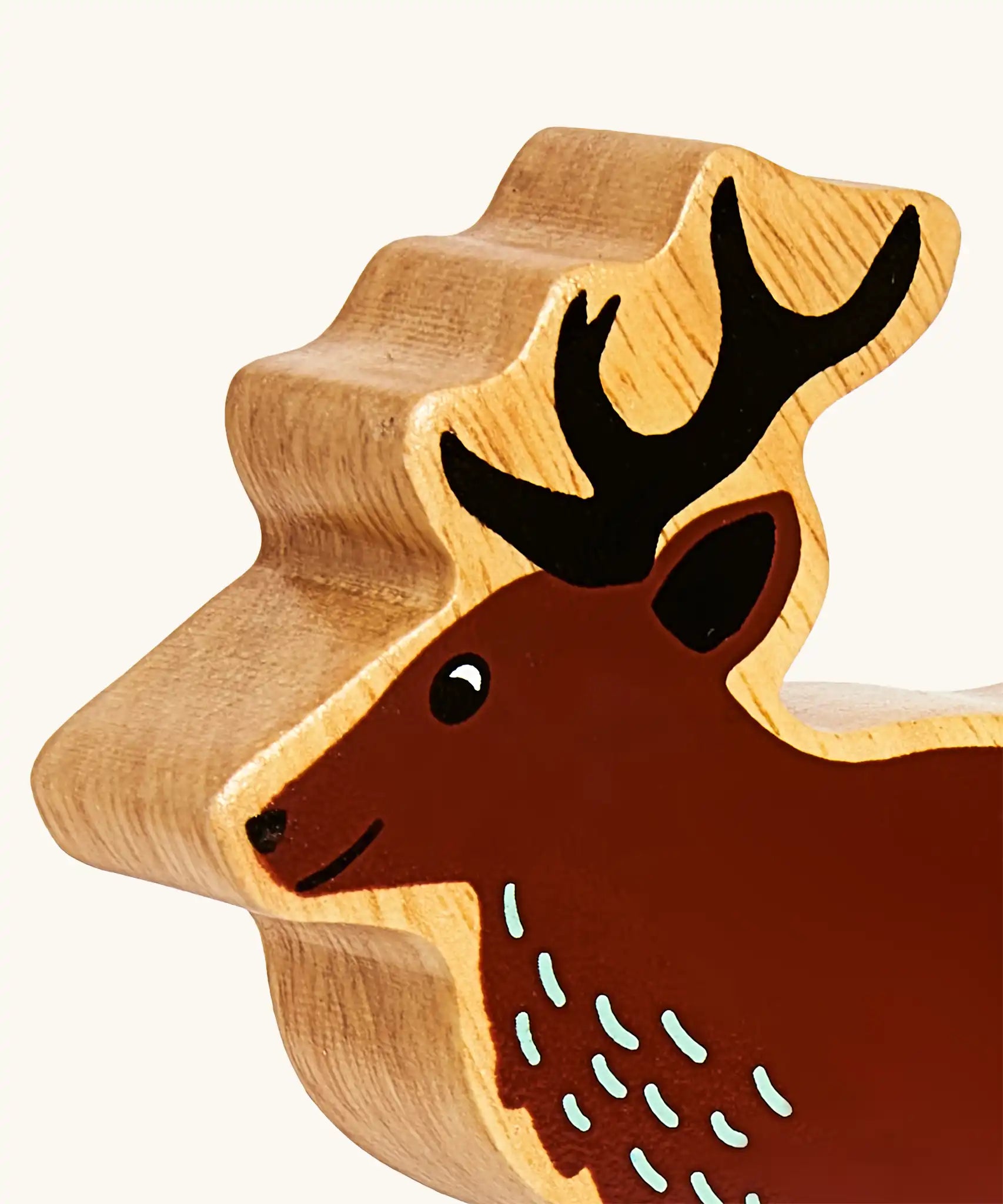 Close up of the painted facial features on the Lanka Kade dark brown stag wooden toy figure.