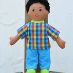 The Lanka Kade dad doll with brown skin and black hair placed on wooden decking. 