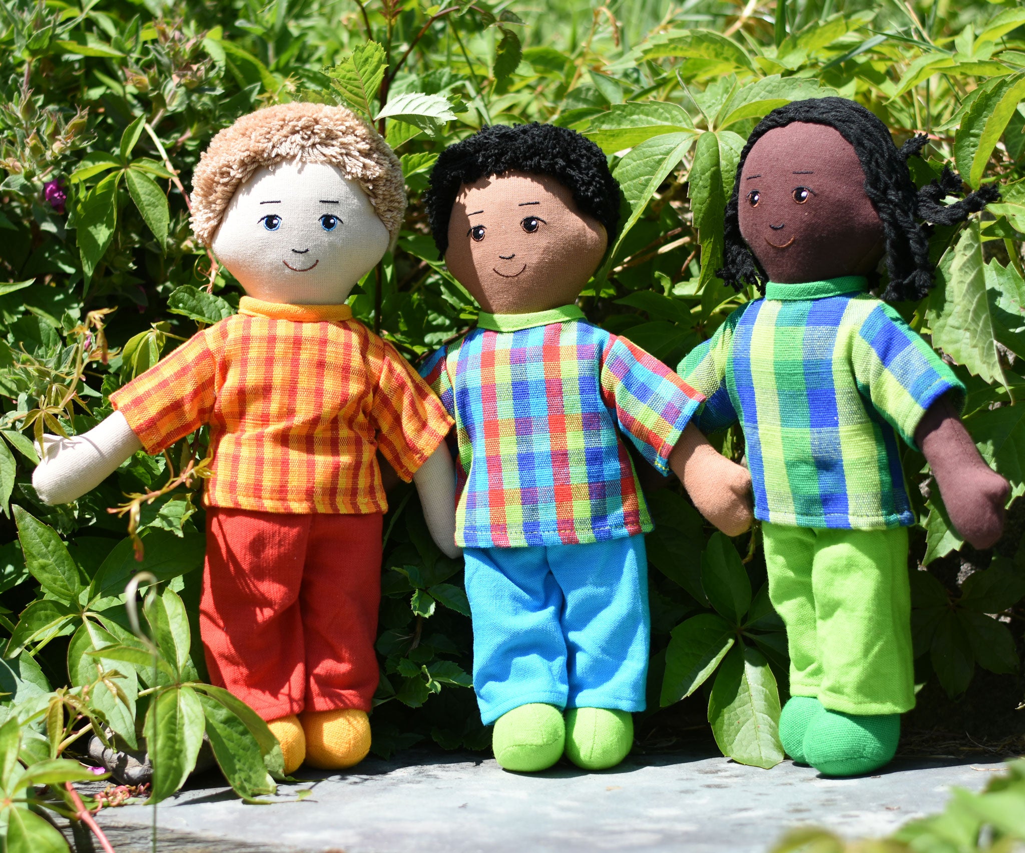 Three Lanka Kade dad dolls placed on a slate surface outdoors.  One doll has white skin and blonde hair, one has brown skin and black hair and the third has black skin and black hair. Their outfits are all made from sari offcut material so will come in random colours. 