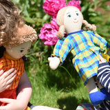 Children playing with Lanka Kade rag dolls in a garden.