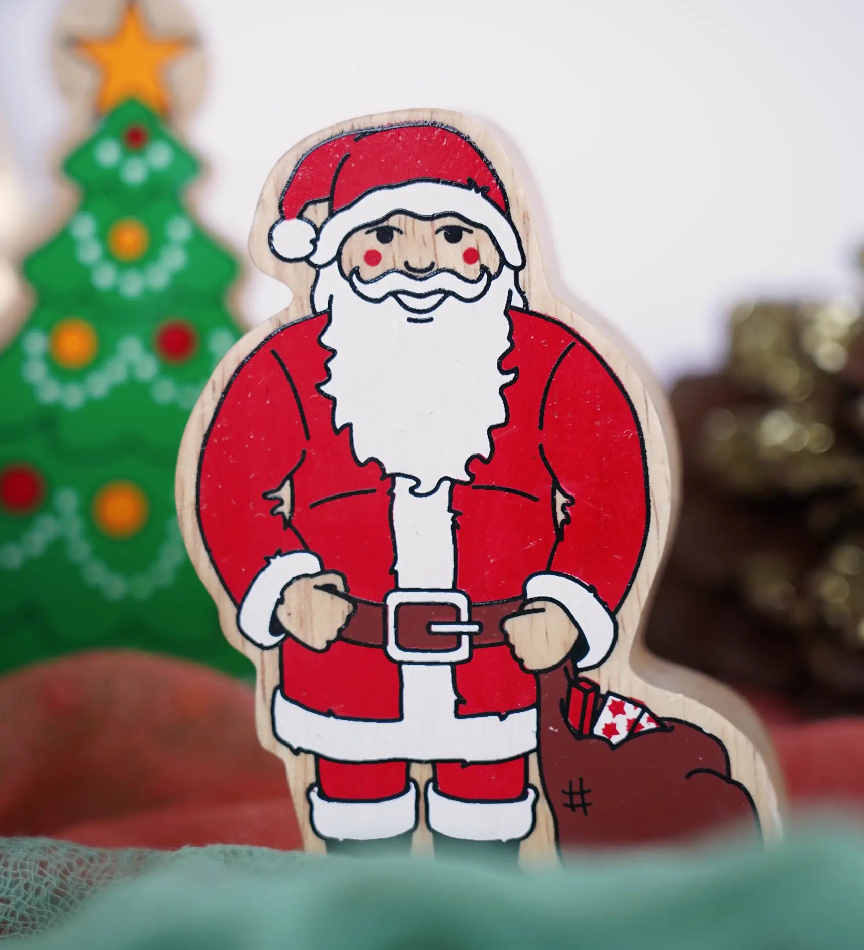 Lanka Kade handcrafted wooden toy figure of Santa Claus, painted in traditional red and white attire with a black belt and boots, holding a brown sack.