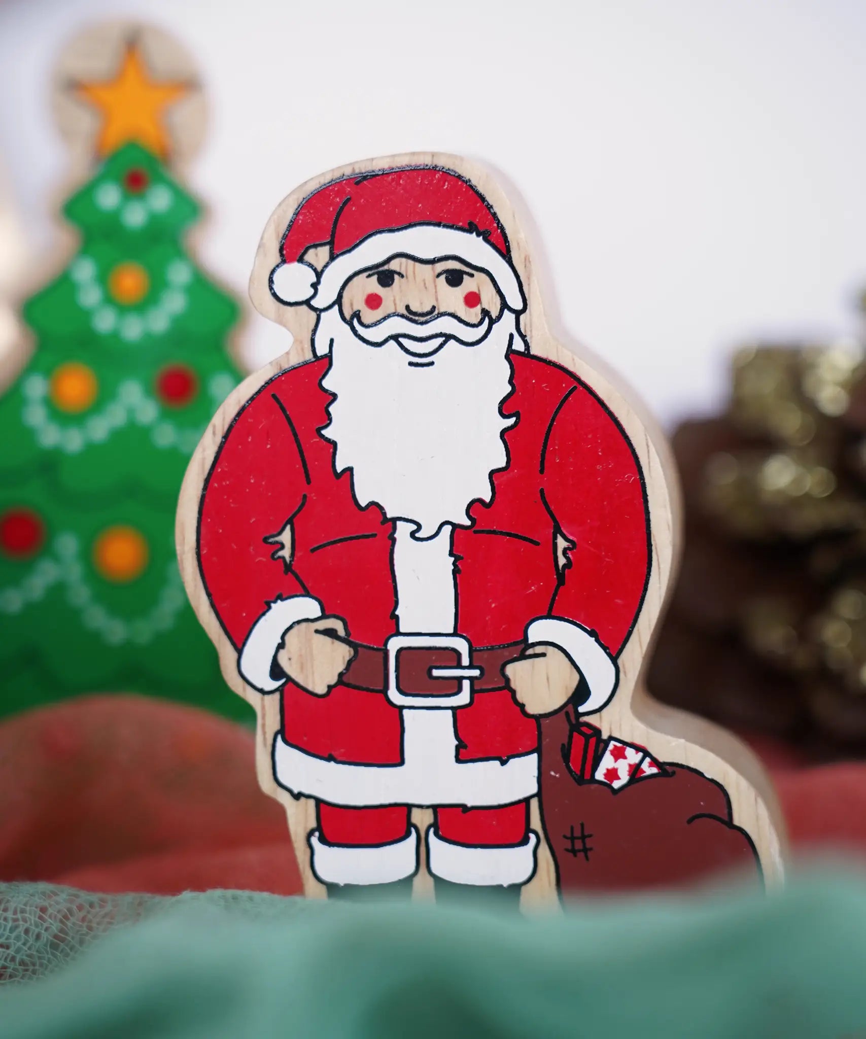Lanka Kade handcrafted wooden toy figure of Santa Claus, painted in traditional red and white attire with a black belt and boots, holding a brown sack.