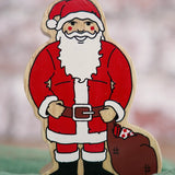 Lanka Kade handcrafted wooden toy figure of Santa Claus, painted in traditional red and white attire with a black belt and boots, holding a brown sack.