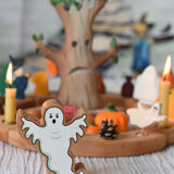 A Lanka Kade wooden toy ghost figure placed in front of a Halloween themed Grimm's celebration ring set up.