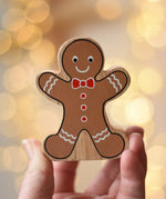 Lanka Kade gingerbread man wooden toy figure in an adult's hand.