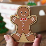 Lanka Kade gingerbread man wooden toy figure in an adult's hand.