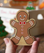 Lanka Kade gingerbread man wooden toy figure in an adult's hand.