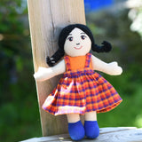A A Lanka Kade Girl Doll with White Skin and Black Hair leaning against a wooden fence post outdoors.
